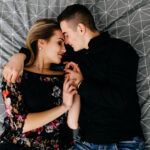 пара лежит на кровати в обнимку и держится за руки